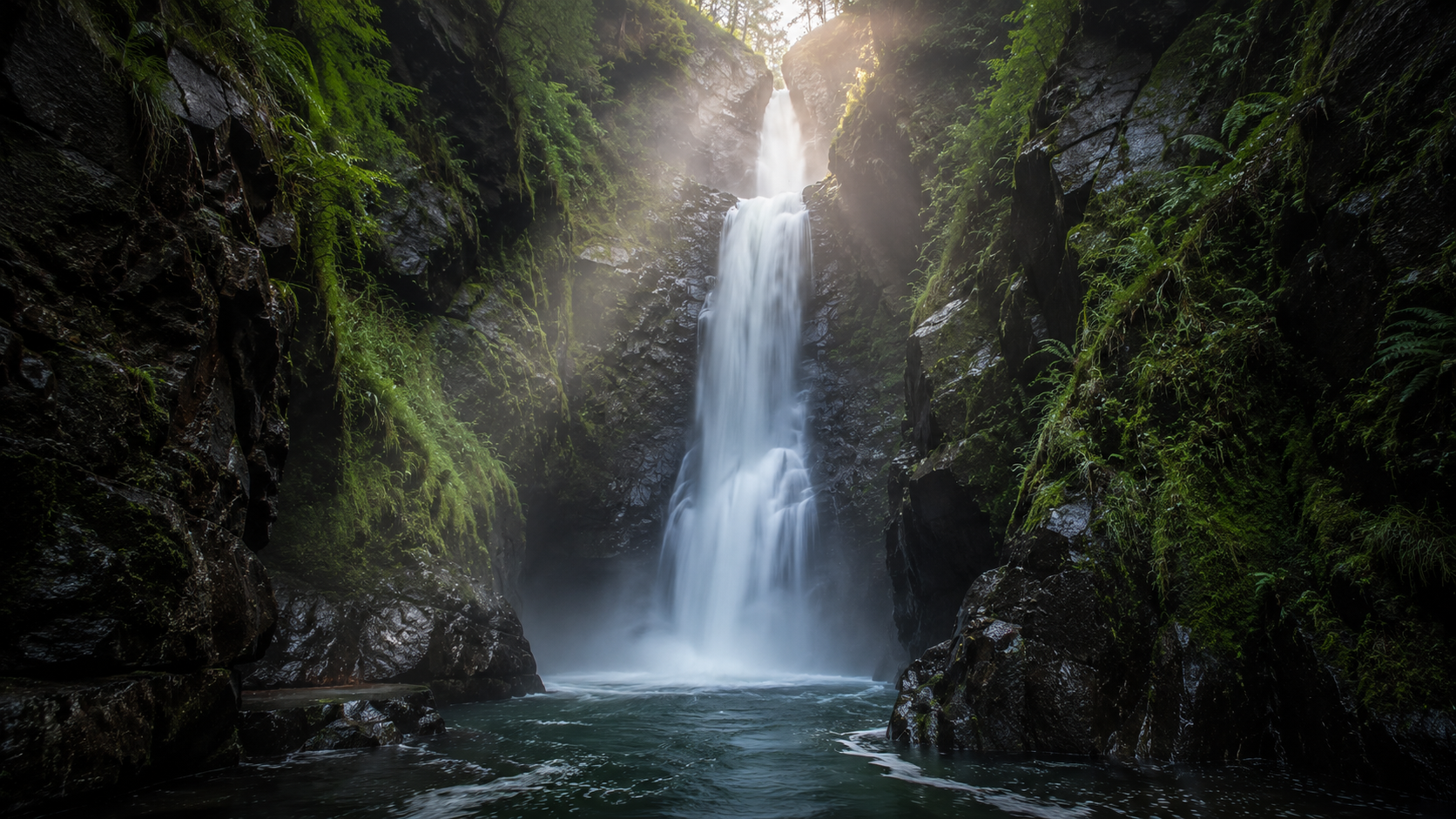Tall waterfall cascading into a pool surrounded by moss-covered gorge walls